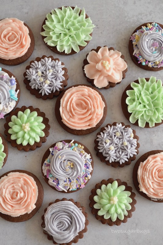 chocolate sugar cookies decorated with pastel buttercream