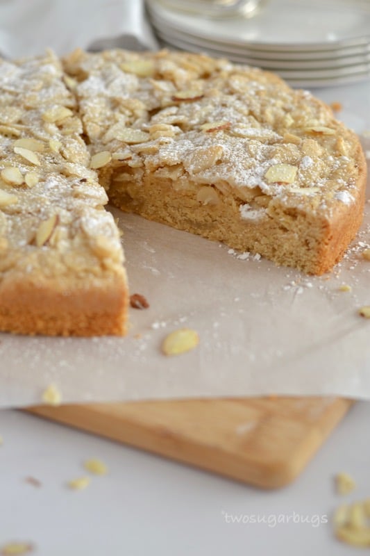 cake on a parchment lined cutting board with a slice missing