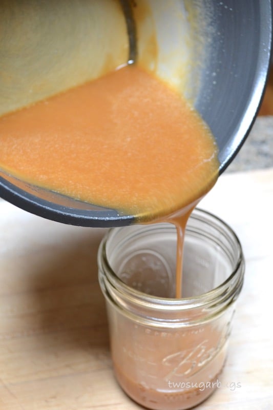 Caramel sauce being poured into a jar