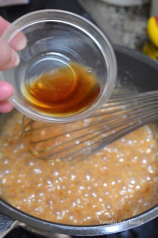Whiskey and vanilla being poured into caramel sauce