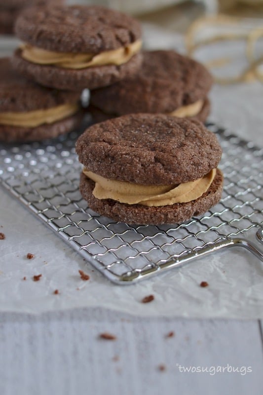 Chocolate Biscoff sandwich cookies on a wire rack.