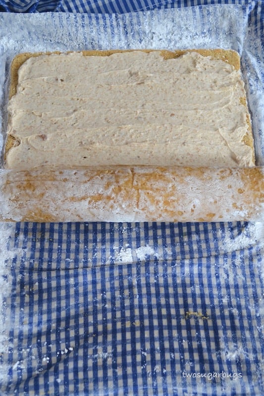 Cake layer with frosting being rolled up.