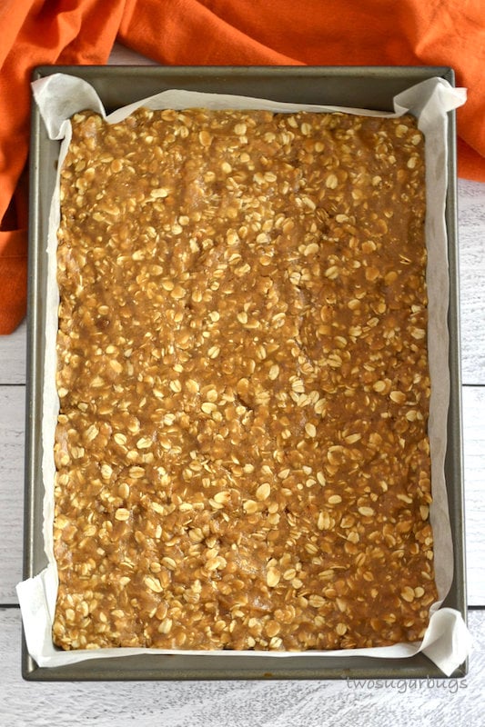 unbaked oatmeal spice layer in parchment lined baking sheet