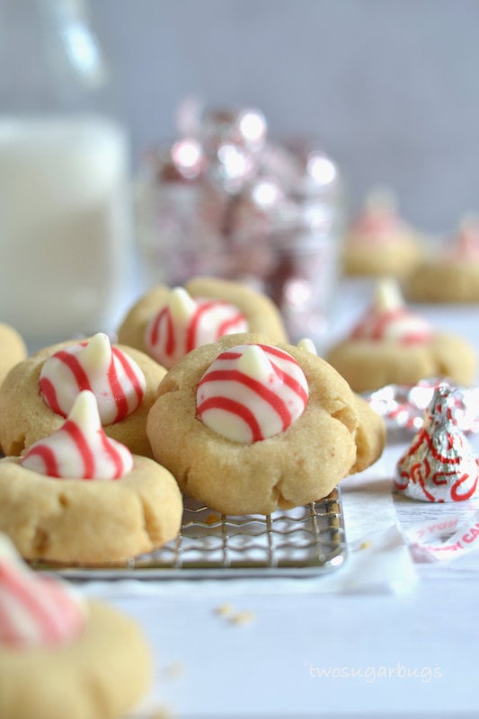 brown butter peppermint blossoms cookies on a cooling rack with kisses and milk in the background