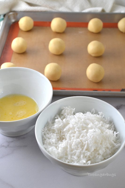 Coconut and egg wash in bowls with shortbread cookie dough balls