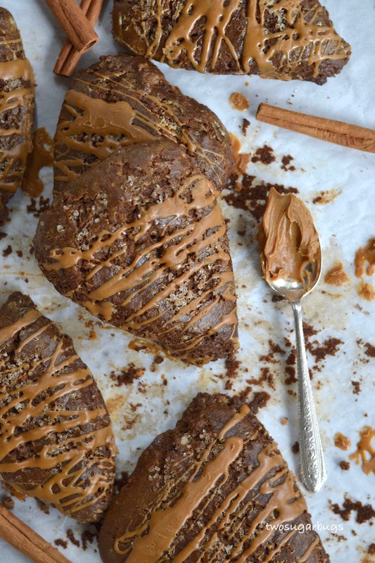 a pile of gingerbread scones on parchment paper with a spoonful of Biscoff spread