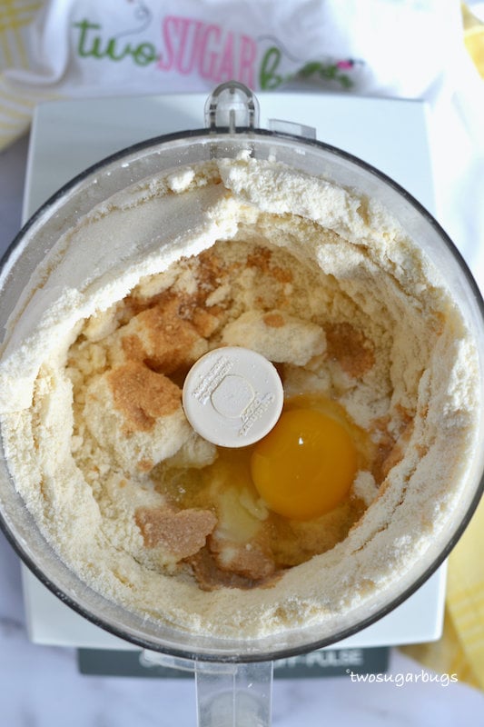 food processor with ingredients including an egg and vanilla
