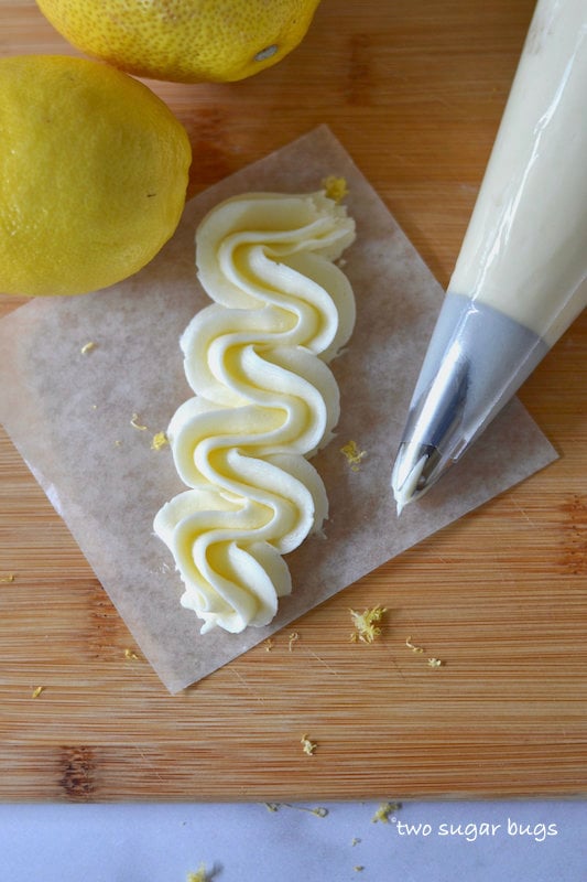 lemons, piping bag and piped frosting on a cutting board