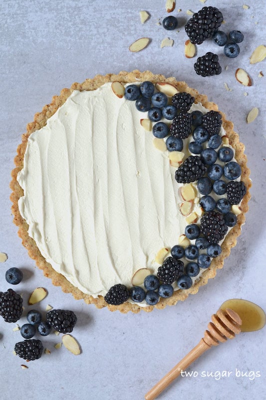 mascarpone tart with berries and a honey spoon