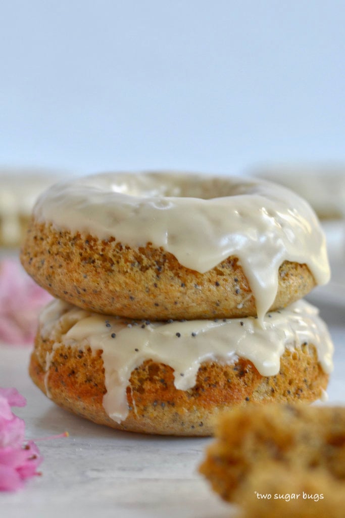 two orange poppy seed donuts stacked