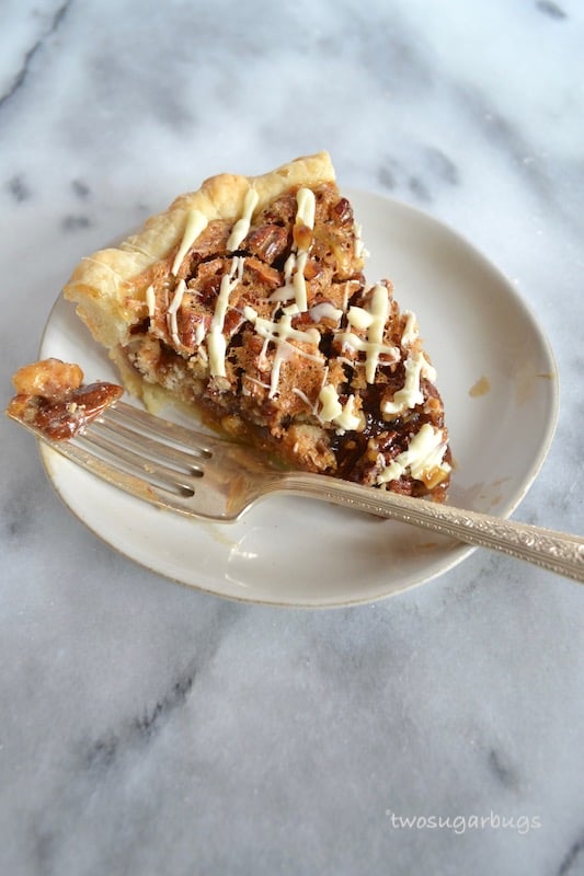 This white chocolate pecan pie is simple to prepare and sure to impress. It has a sweet and gooey center with chunky pecans and chunks of white chocolate. #twosugarbugs #pecanpie #thanksgivingpie #whitechocolate