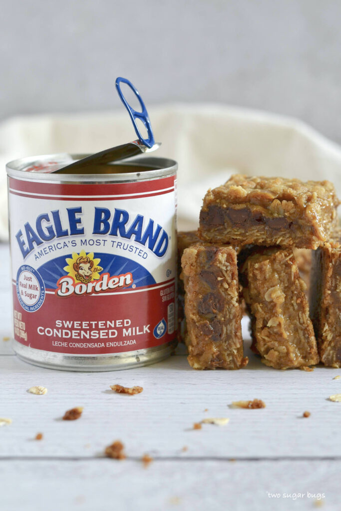 pumpkin caramel bars stacked next to an Eagle Brand can
