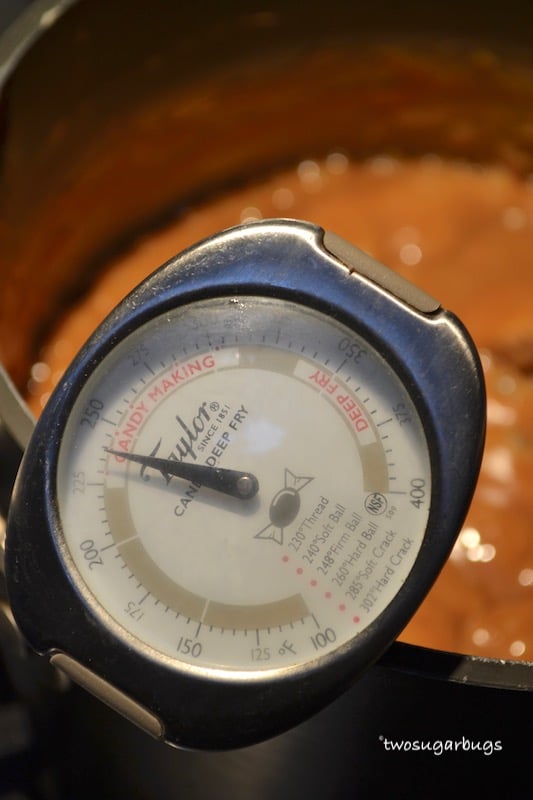 candy thermometer in saucepan showing caramels at the correct temperature