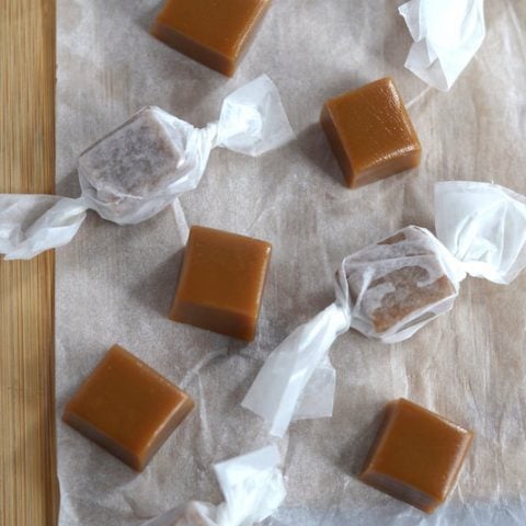 wrapped and unwrapped caramels on parchment paper