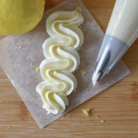 lemons, piping bag and piped frosting on a cutting board
