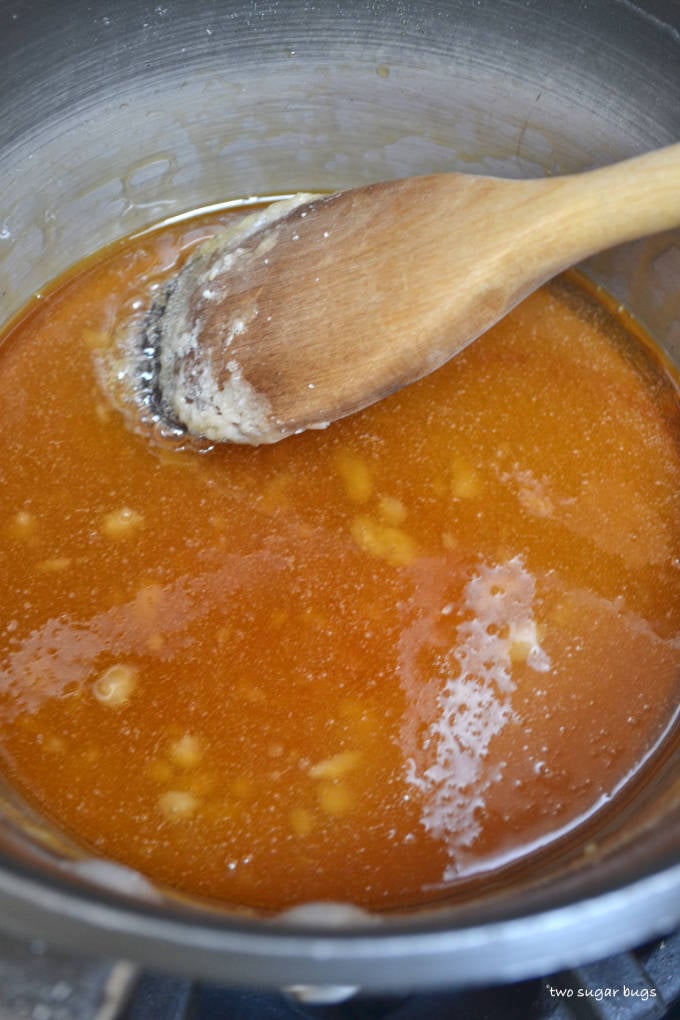 sugar melting in a sauce pan with a wooden spoon