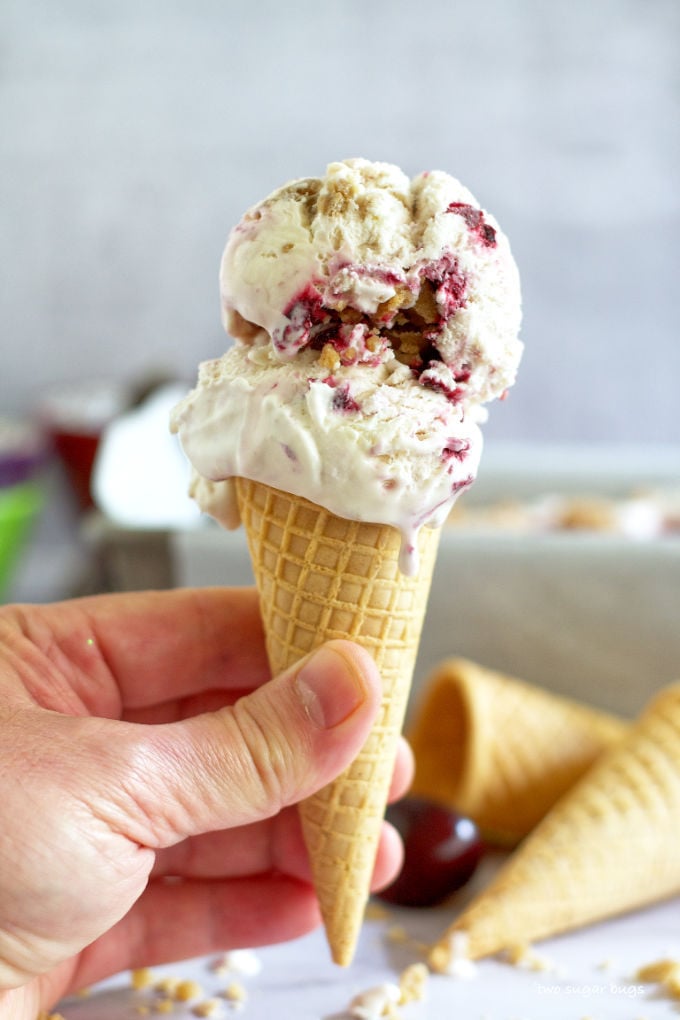 hand holding a cone of cherry bourbon crumble ice cream