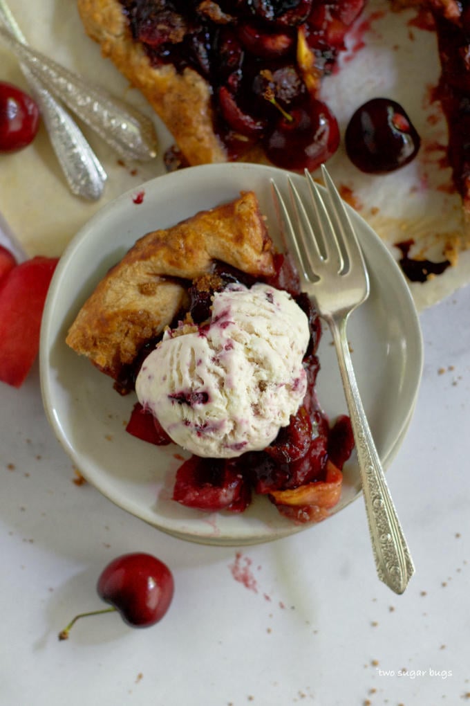 slice of crostata on a plate with a scoop of ice cream and a fork