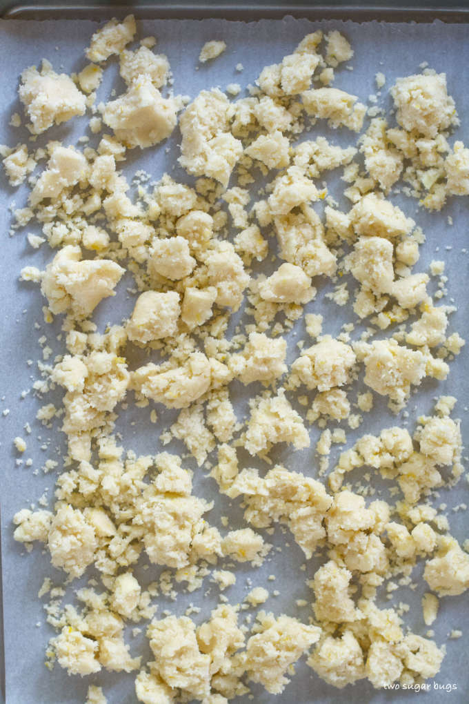unbaked cookie crumbles on a parchment lined baking pan