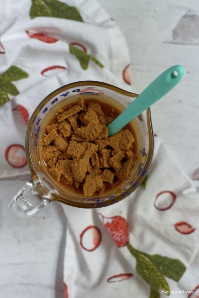 measuring cup with cookie butter caramel and chopped cookies