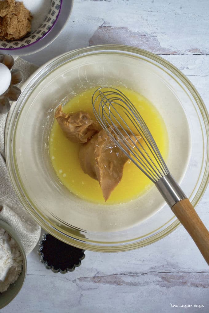 melted butter and peanut butter in a bowl with a whisk
