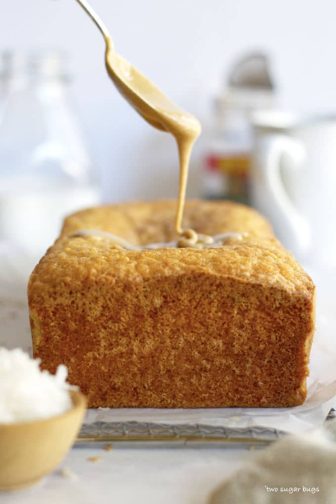 spoon drizzling glaze on kona coconut loaf cake