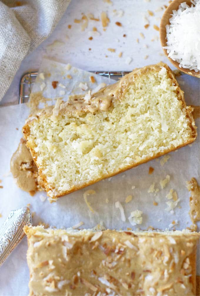 slice of coconut cake on parchment lined cooling rack