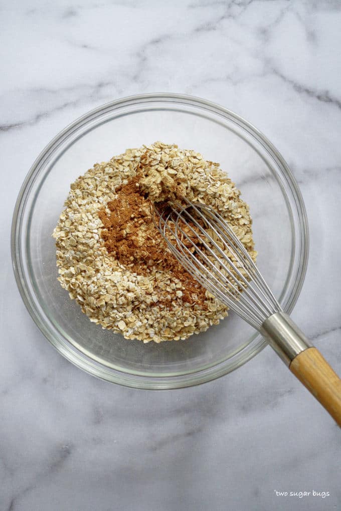 oats and spices in a bowl with a whisk