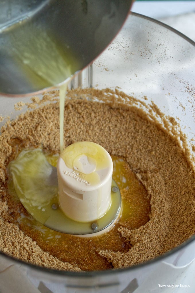 butter being poured into graham cracker crumbs