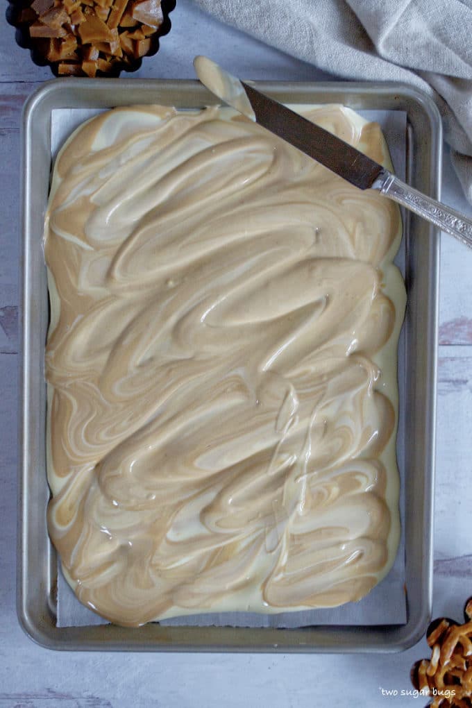 melted white chocolate and cookie butter swirled together on a baking sheet