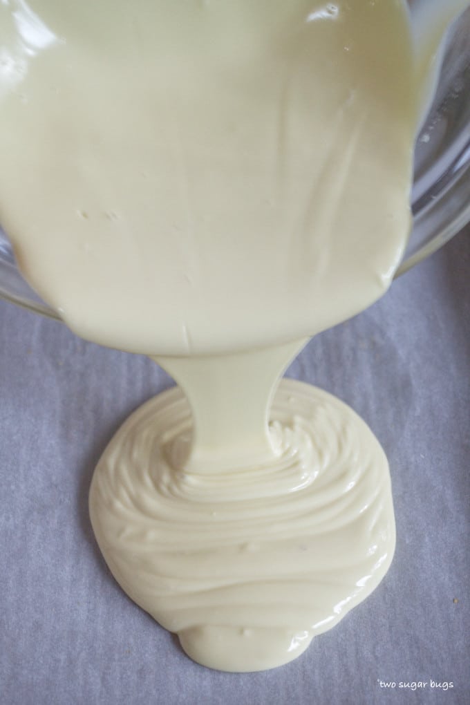 melted white chocolate being poured onto a baking pan