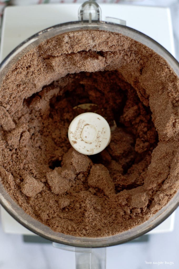 double chocolate peppermint cookie dough looking like wet sand in the bowl of a food processor