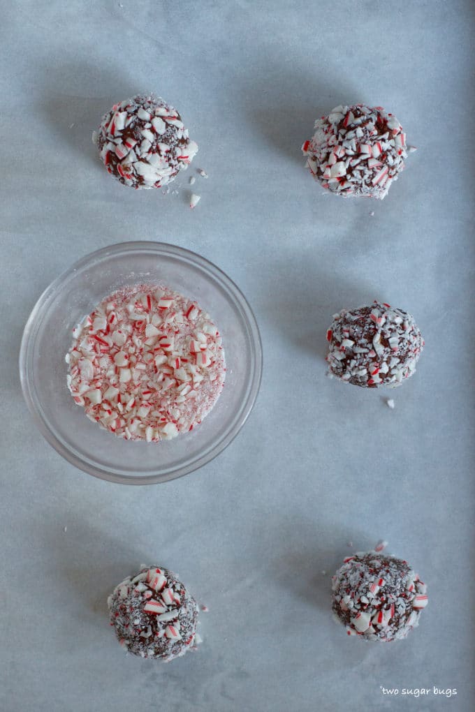 cookie dough balls rolled in peppermint on a baking pan