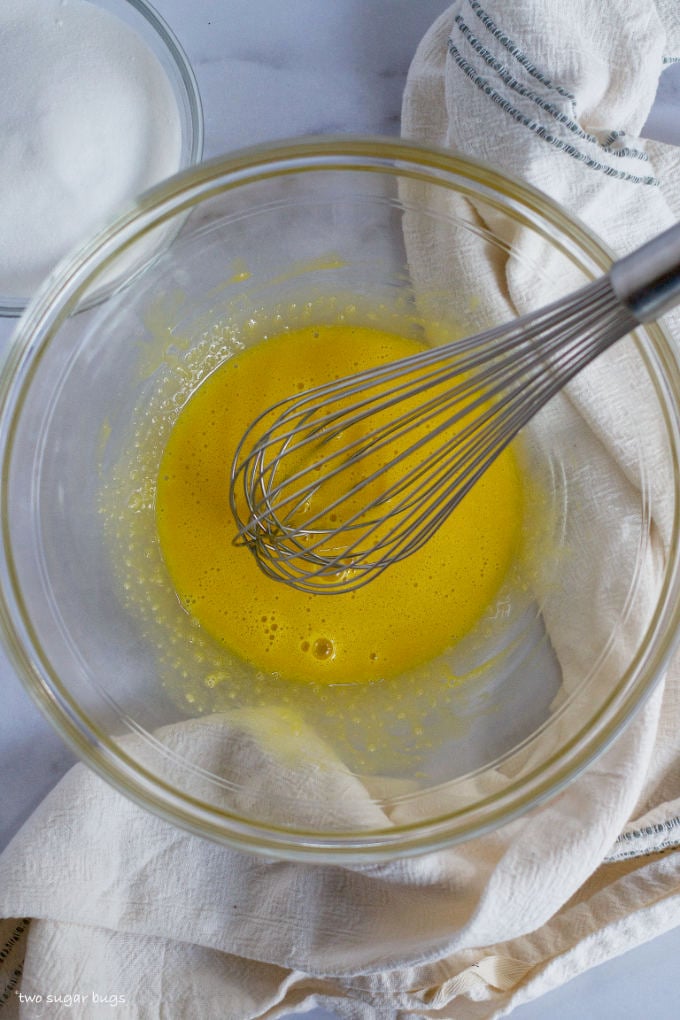 whisked egg yolks in a bowl with a whisk