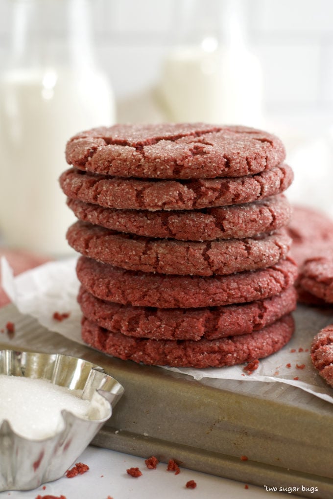 stack of red velvet sugar cookies on a baking sheet pan