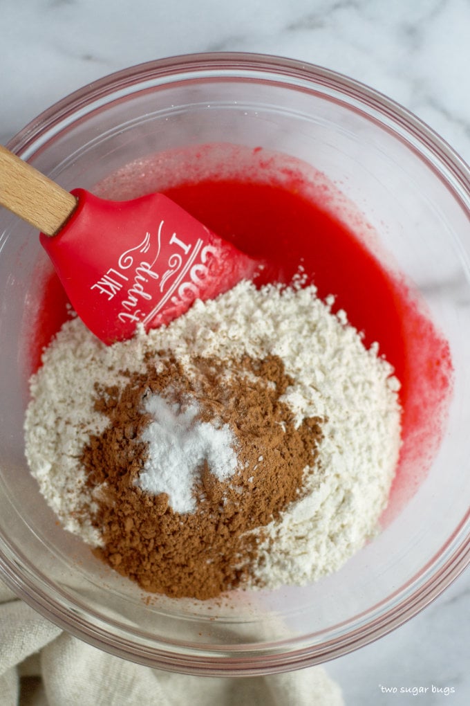 dry ingredients on top of wet ingredients in a glass mixing bowl