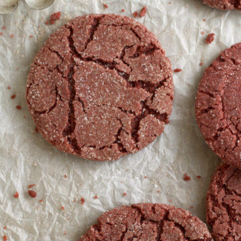 close up of red velvet sugar cookies on parchment paper