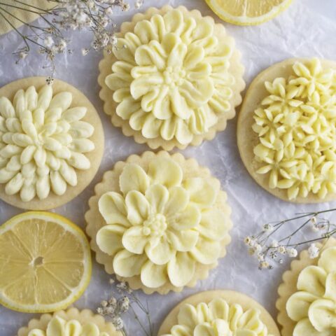 lemon cut out sugar cookies on parchment paper with lemon slices