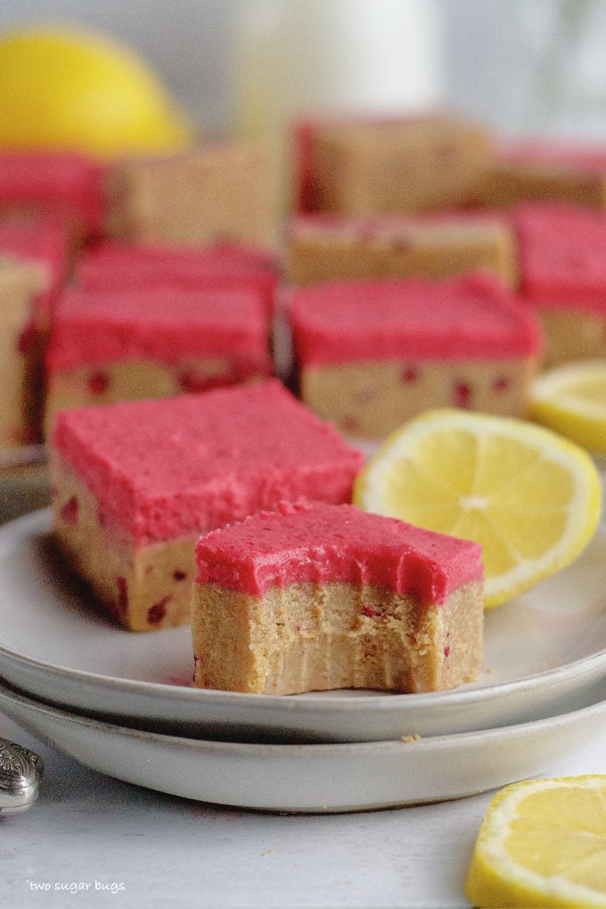 lemon raspberry bar with a bite out of it on a plate