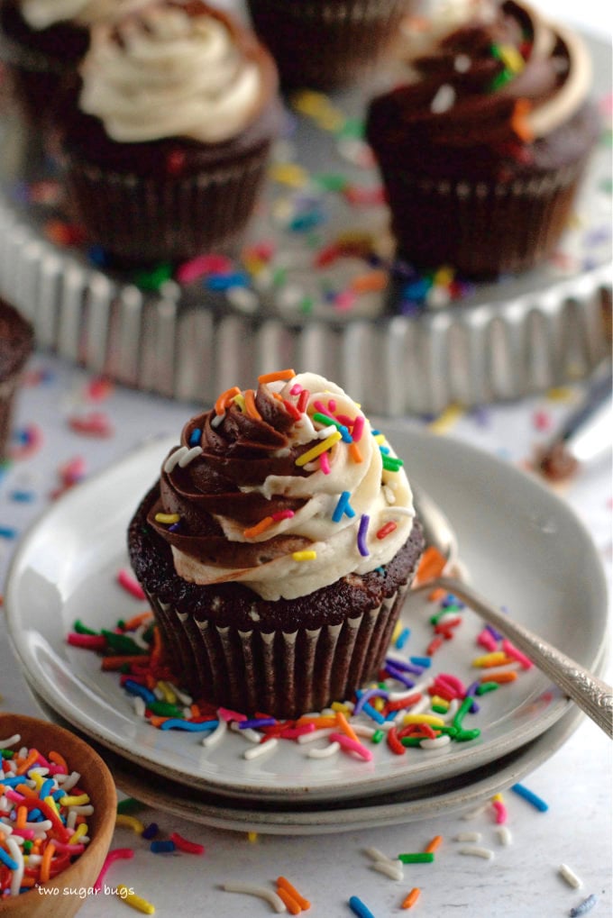 chocolate cupcakes with buttercream and sprinkles on a plate