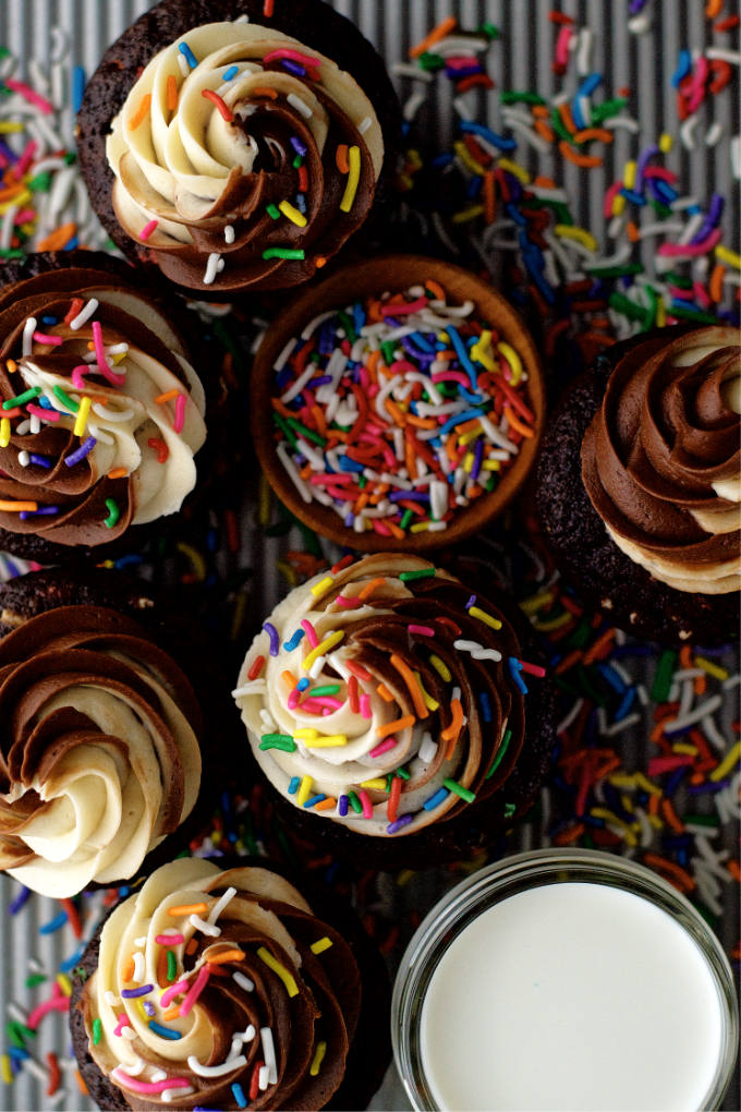 small batch chocolate cupcakes on a baking pan with milk and sprinkles