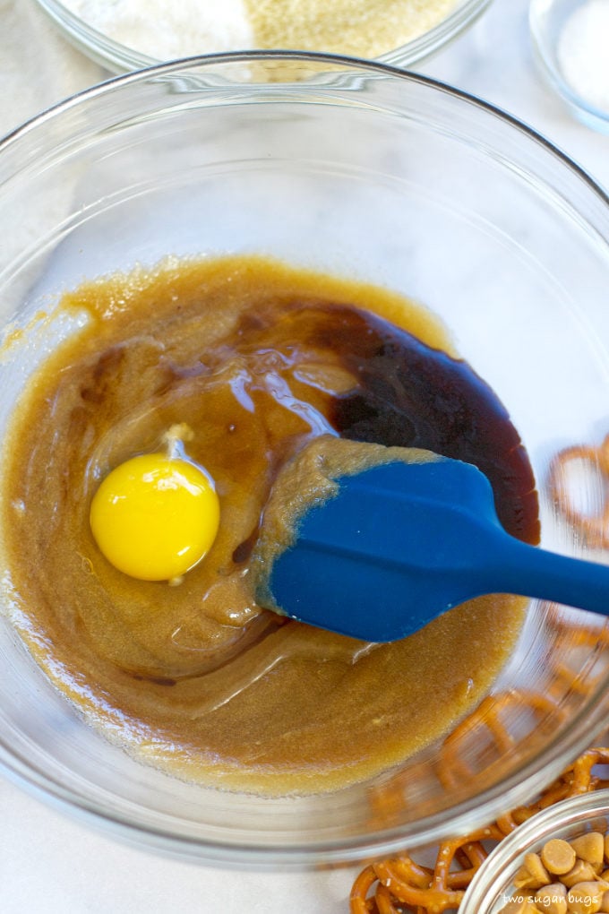 egg, vinegar and vanilla being mixed into sugars and butter
