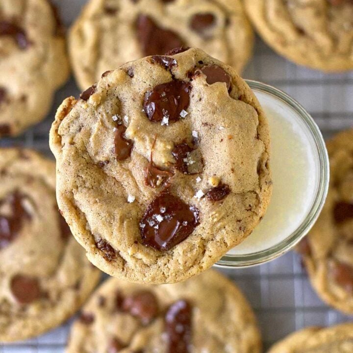 malted chocolate chip cookie sitting on top of a glass of milk