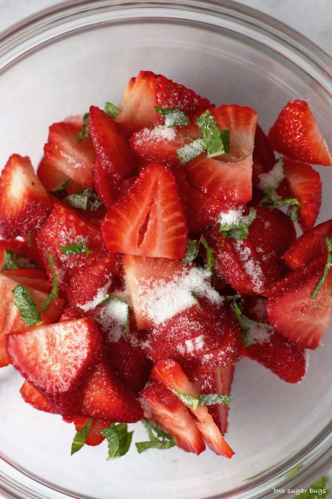 fresh strawberry slices, sugar and mint in a bowl
