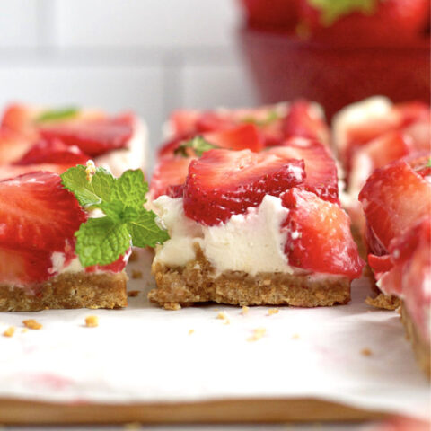 no bake mascarpone cheesecake bars on a parchment lined cutting board