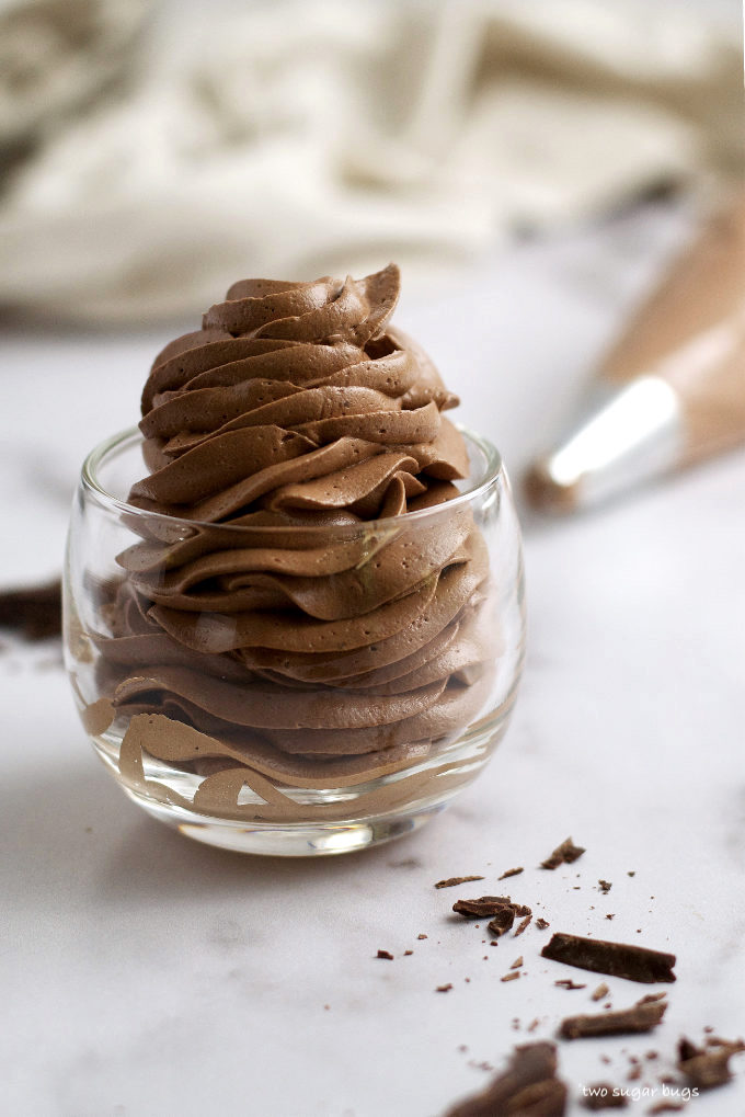 a glass cup filled with piped chocolate swiss meringue buttercream