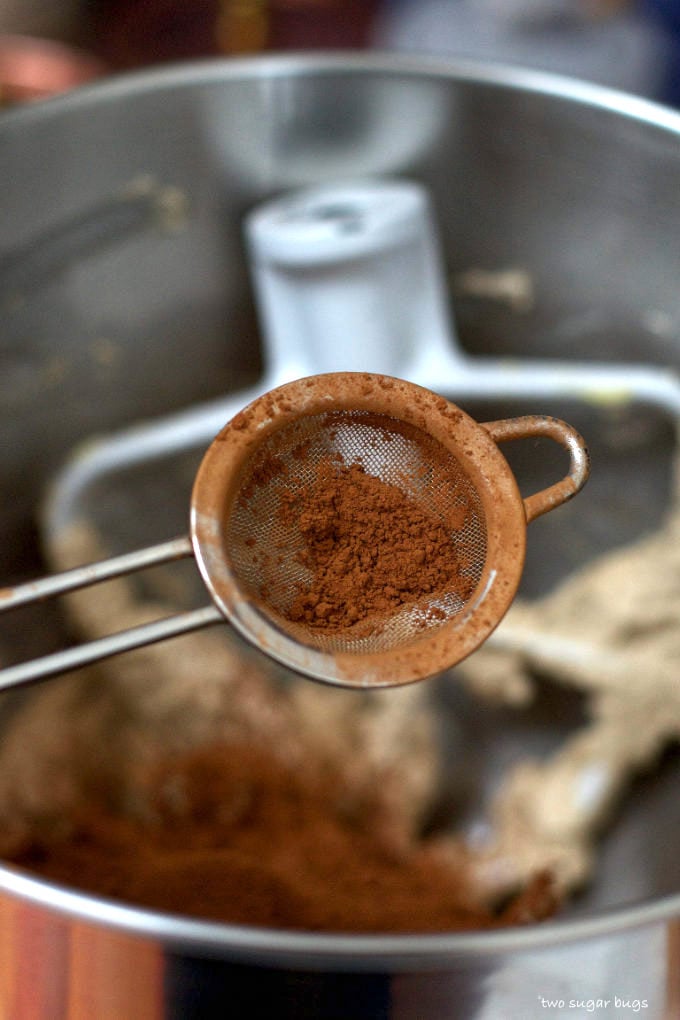 cocoa powder being sifted into the chocolate swiss meringue buttercream