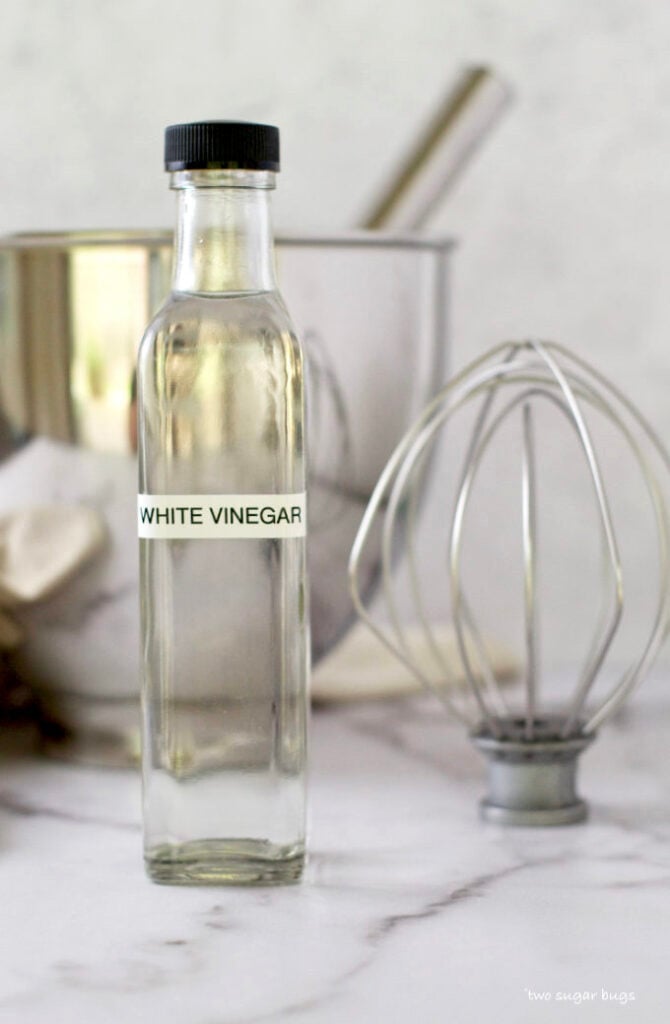 bottle of white vinegar and a mixer whisk