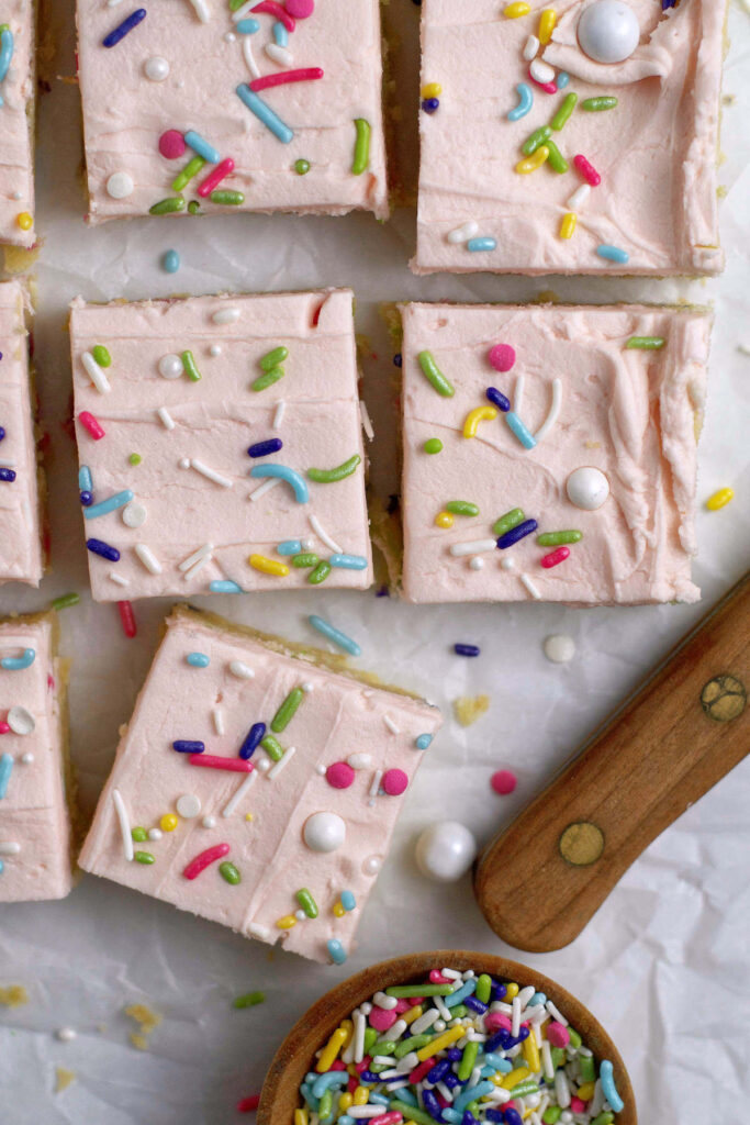 cut sugar cookie bars on parchment paper with extra sprinkles