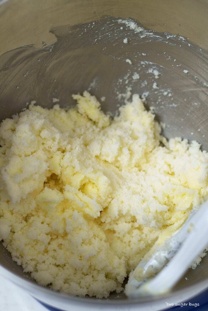 butter and sugar being creamed together in a mixing bowl